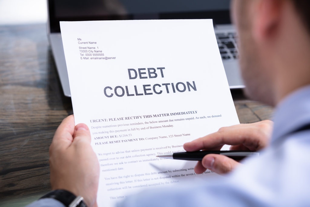 person deciding whether to pay off old debt or let it fall off a credit report in 2026.webp